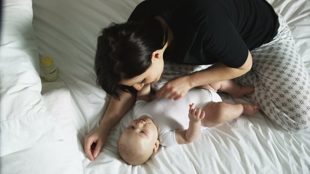 mother and baby on a bed