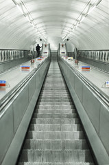 Escalator facing down with one anonymous commuter