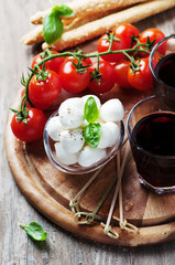 Mozzarella, tomato and basil on the wooden table