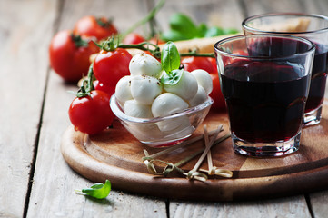 Mozzarella, tomato and basil on the wooden table