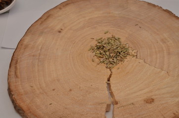 Fennel seeds on a cross-cut a tree