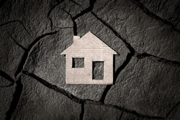 Paper house on cracked earth