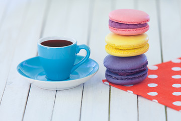 Obraz na płótnie Canvas Cup of coffee and macarons on polka dot napkin