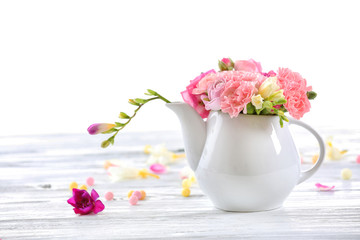Beautiful spring flowers in teapot isolated on white