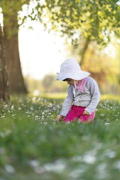 Cute little girl playing in the park on spring day