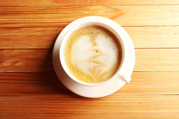Cup of coffee latte art on wooden table, top view