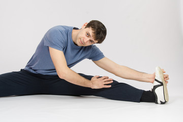 Obraz premium Athlete stretches the muscles of left leg