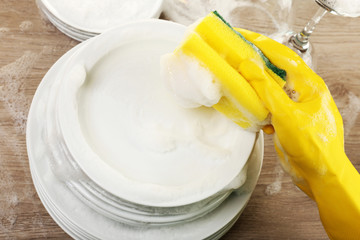 Female hand washing dish close up