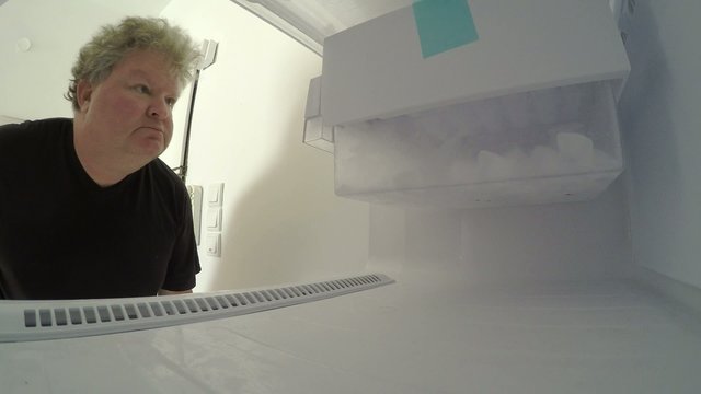 4K UHD A sad man in diet looks inside empty freezer MRL