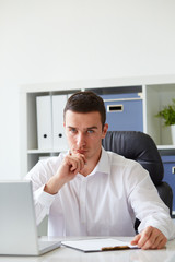 Fototapeta premium Pensive young businessman with notebook