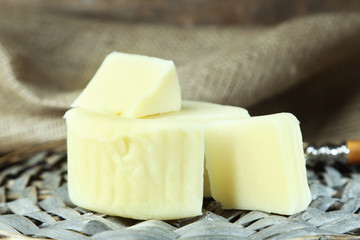 Cheese on wicker tray and sackcloth, closeup