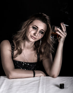 Depressed young woman with a glass of whiskey and a cigarette