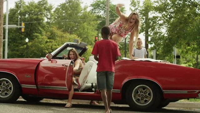 Medium panning shot of convertible car arriving at car wash / Pleasant Grove, Utah, United States
