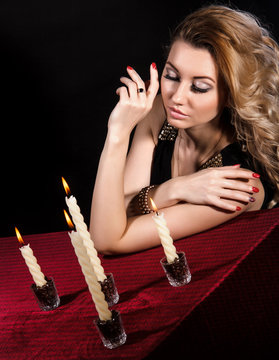 Beautiful young woman near the candles