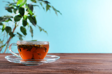 Cup of green tea on table on green background