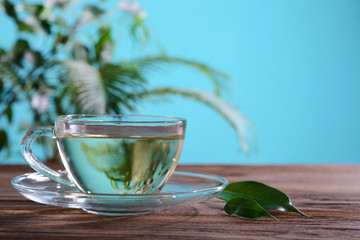 Cup of green tea on table on green background