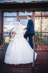 Bride and groom standing on stairs