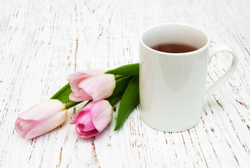 Fototapeta na wymiar Cup of tea and pink tulips