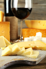 Various types of cheese with wine on table close up