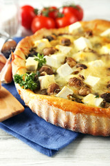 Cheese pie with mushrooms, herbs and sour creme, on wooden table background