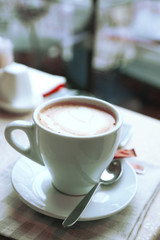 Cup of cappuccino on table in cafe