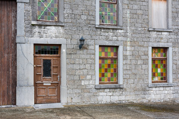 Fototapeta na wymiar Ancient house with brick wall and colorful windows