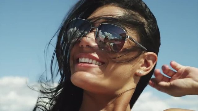 CU Young woman wearing sunglasses laughing / Lake Powell, Utah, USA