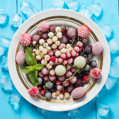 Frozen berry on turquoise background top view
