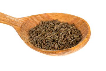dried cumin in a wooden spoon
