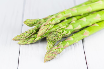 Fresh green asparagus on a light wooden background