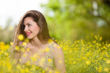 Naklejka premium Beautiful young girl among yellow flowers