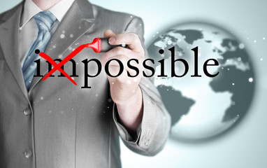 Businessman Hand turning the word Impossible into Possible with