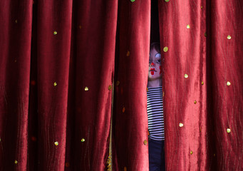 Boy Clown Peering Through Stage Curtains