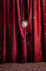 Boy Clown Peering Through Stage Curtains