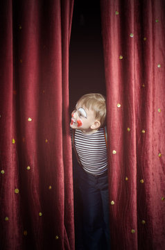 Boy Dressed Up as Clown Peeking Thru Stage Curtain