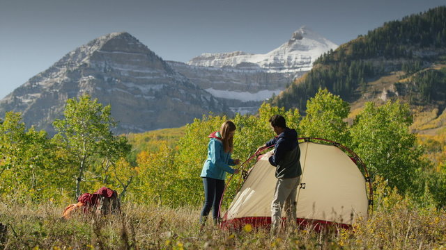 Wide shot of hikers assembling camping tent near mountain / American Fork Canyon, Utah, United States