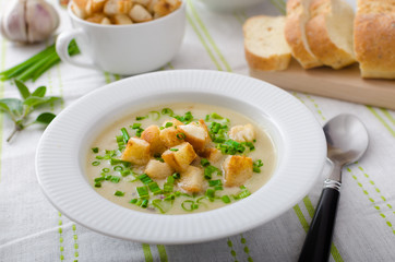Garlic soup with croutons, spring onions and chives