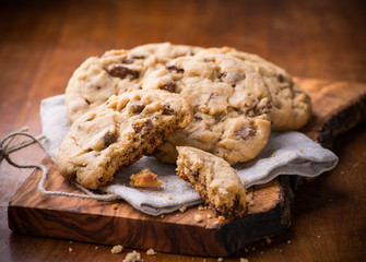 Chocolate chip cookies on napkin over olive wood board