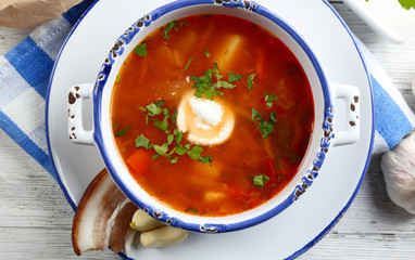 Ukrainian beetroot soup - borscht, on blue napkin, on wooden background