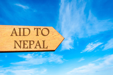 Wooden arrow sign with message AID TO NEPAL