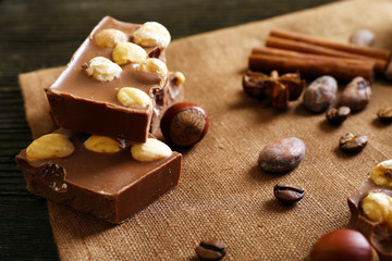 Delicious chocolates with nuts spices on table, closeup