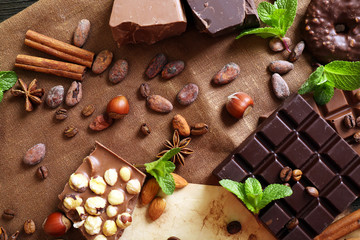 Chocolate with mint, spices and coffee beans on table, closeup