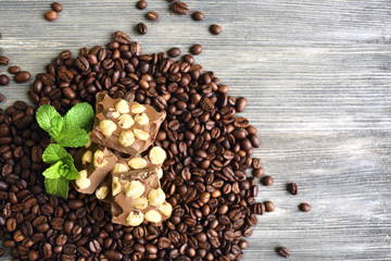 Chocolate with mint and coffee beans on wooden table, top view
