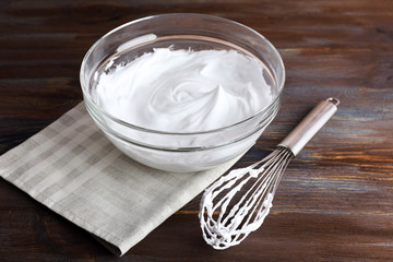 Whipped egg whites for cream on wooden background