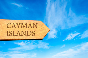Wooden arrow sign pointing destination CAYMAN ISLANDS