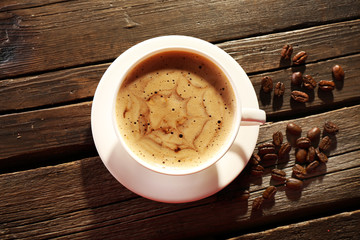 Cup of coffee latte art with grains on wooden background