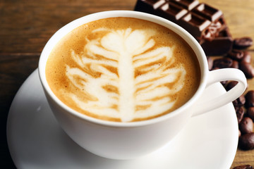 Cup of coffee latte art on wooden table, closeup