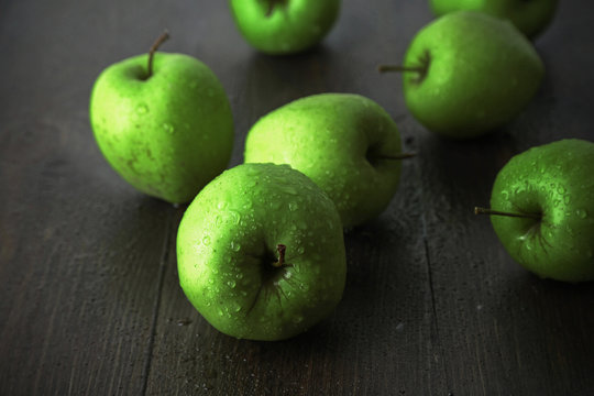 Green apples on wooden background