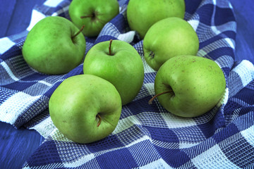 Green apples on squared fabric, closeup