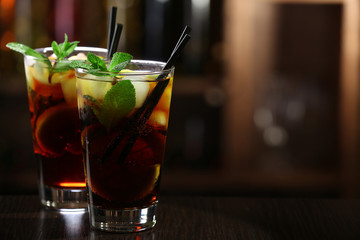 Glass of cocktail in bar on bright blurred background